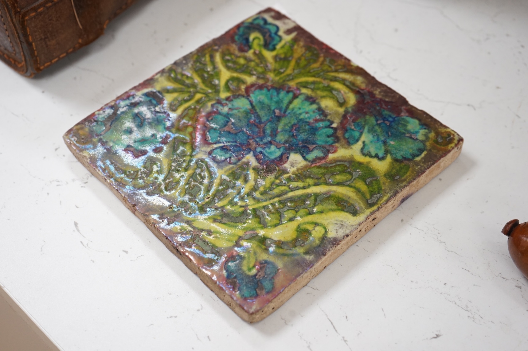 In the manner of William de Morgan, a Persian inspired experimental glazed tile, unmarked, 15cm wide